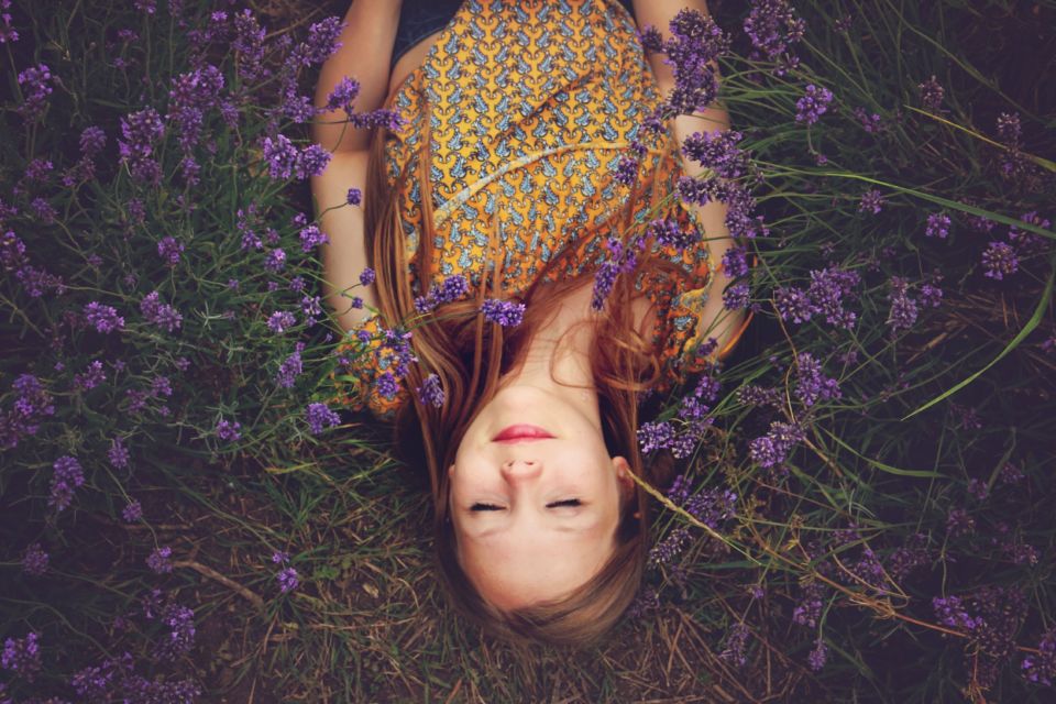 Mädchen liegt zwischen Blumen