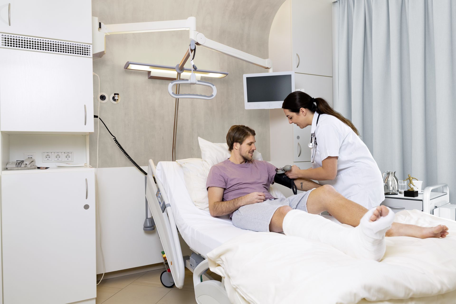Mann mit Gipsbein im Krankenhausbett