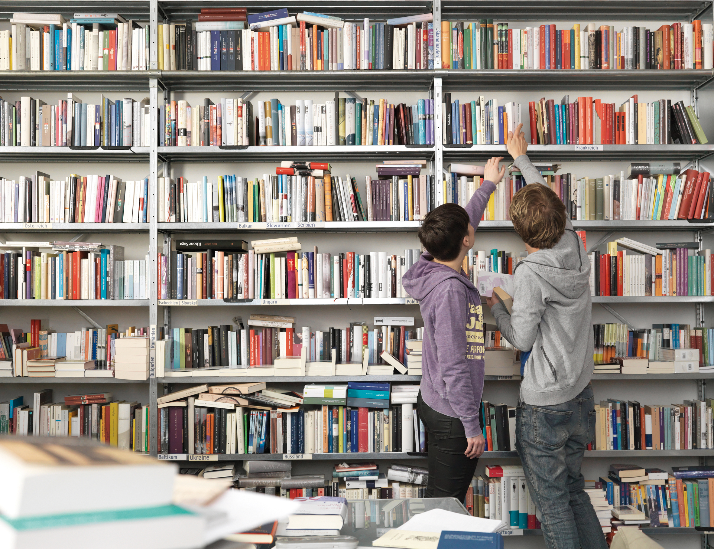 Two people standing in front of a bookshelf