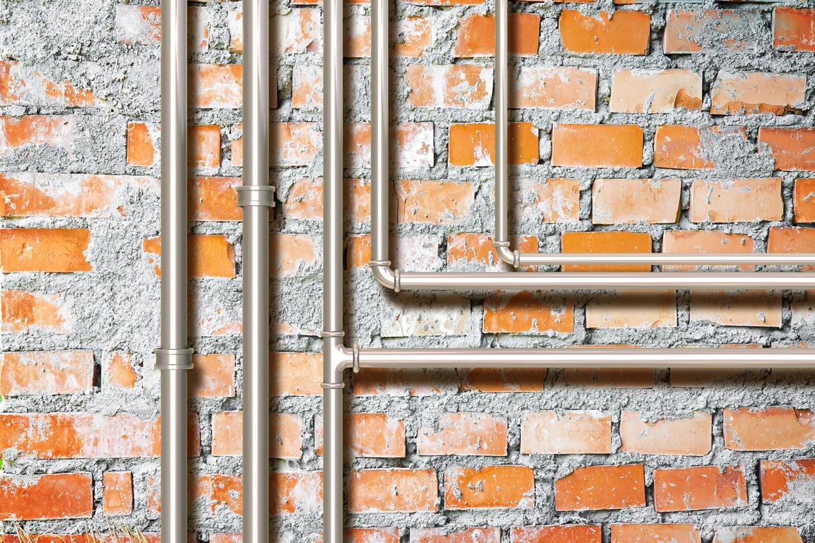 Rohre auf unverputzter Wand