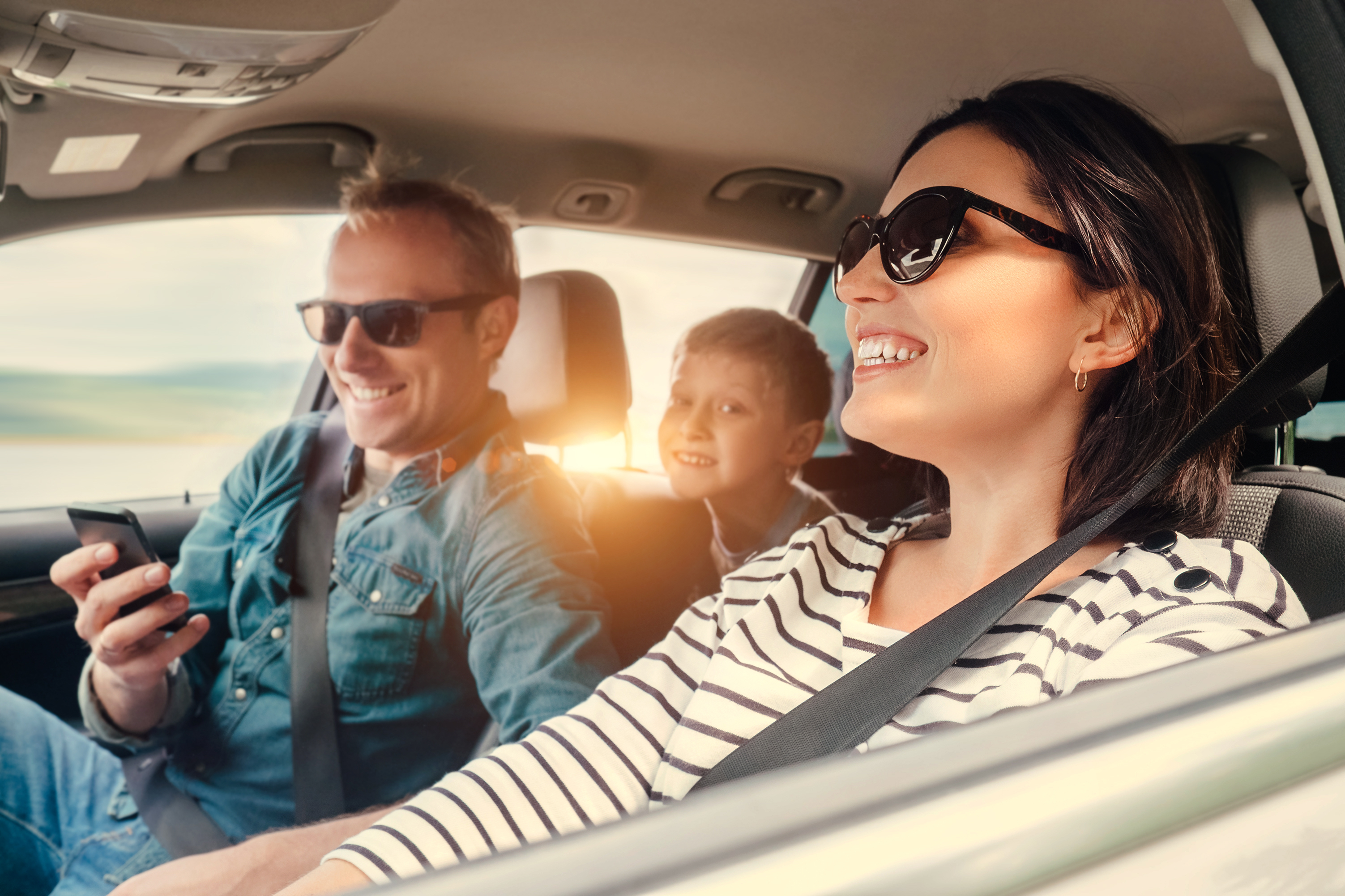 Dreikoepfige Familie in einem Auto