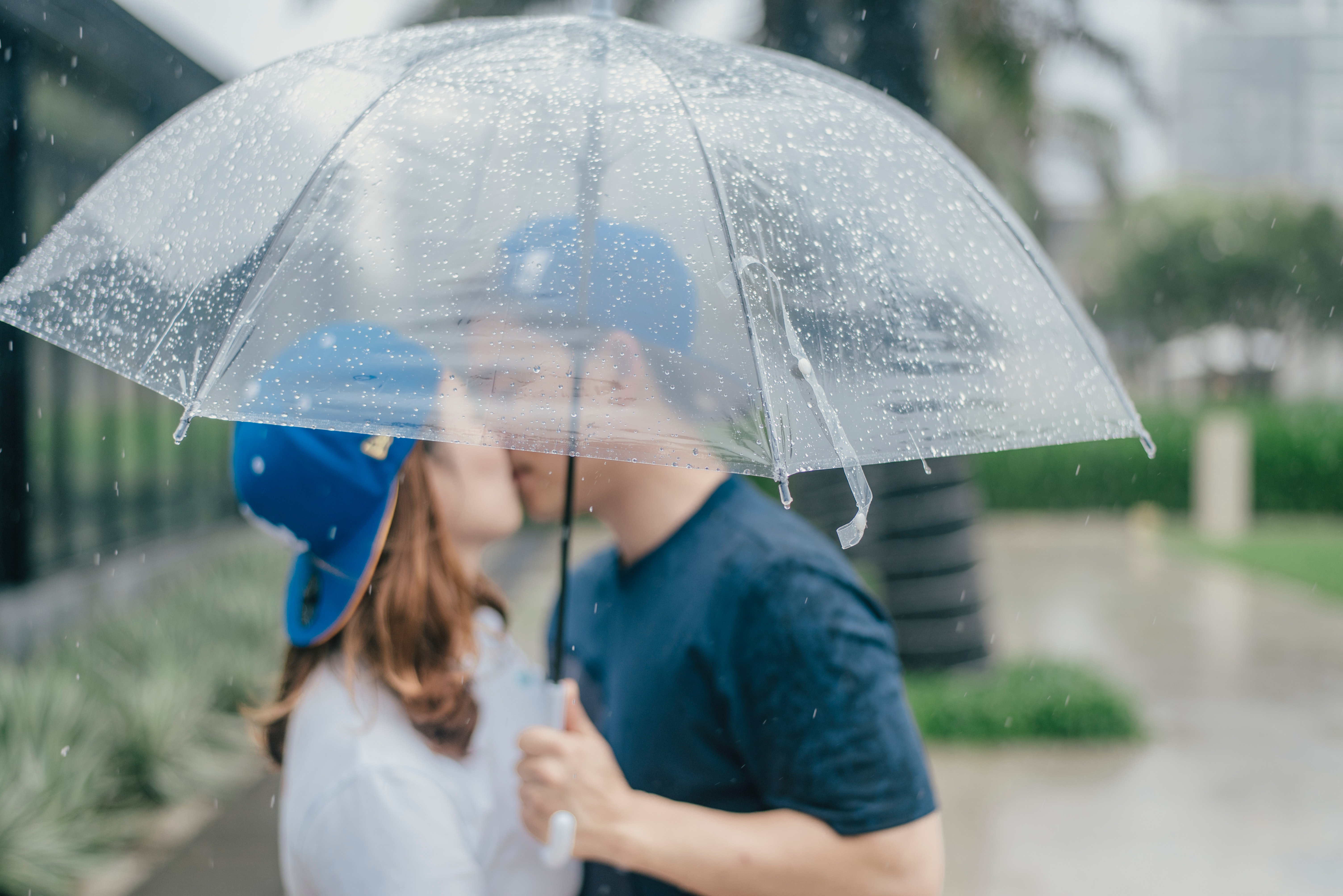 Pärchen küsst sich unter einem Regenschirm